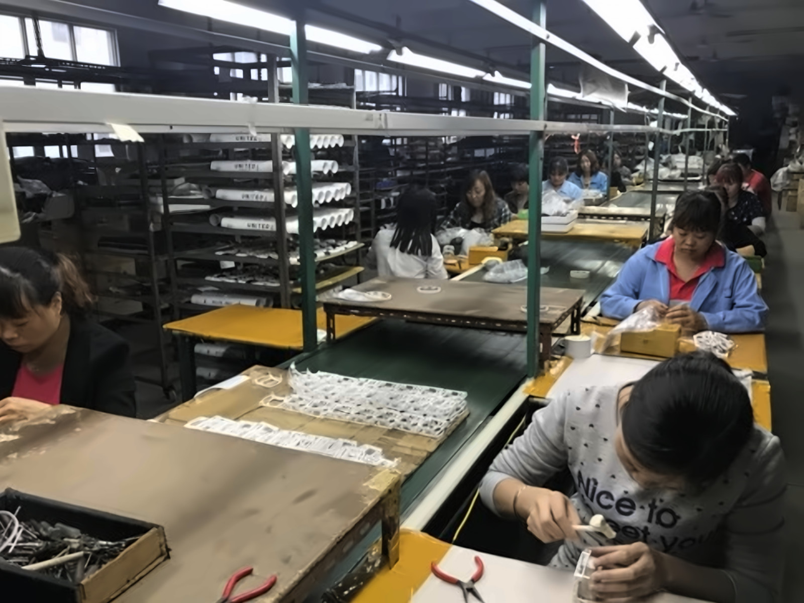 Assembly line workers fitting small parts